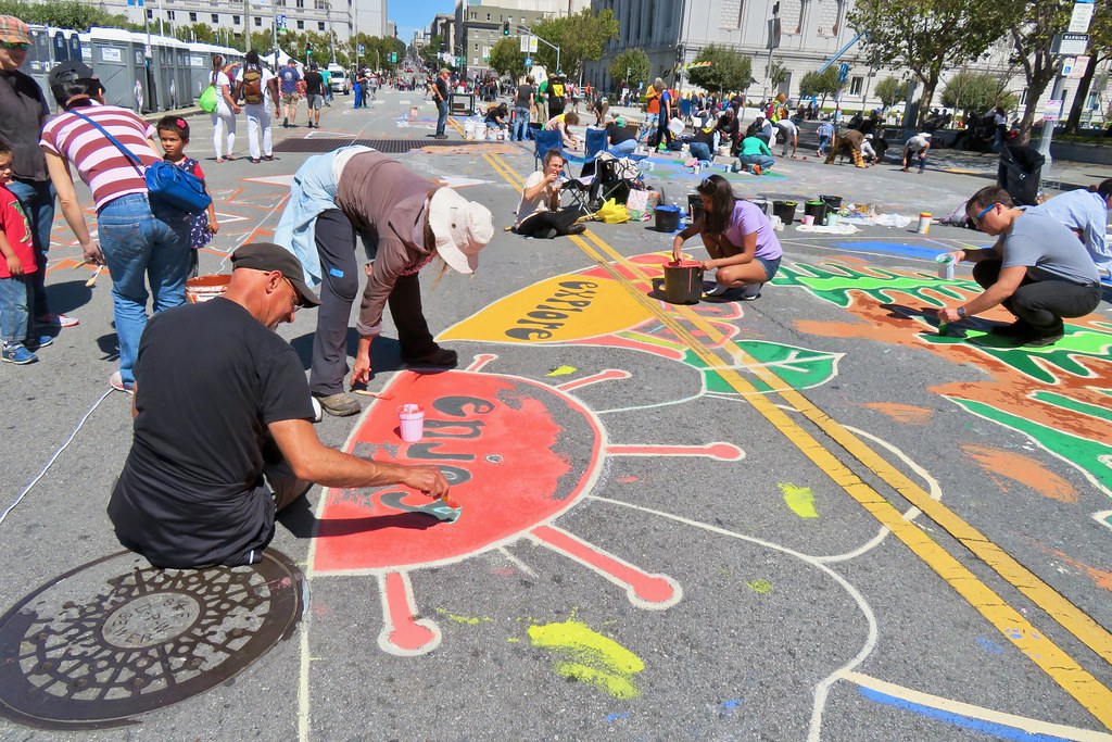 Arts for social change. A group of people painting on the ground